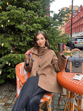 a lady wears a brown double-faced coat